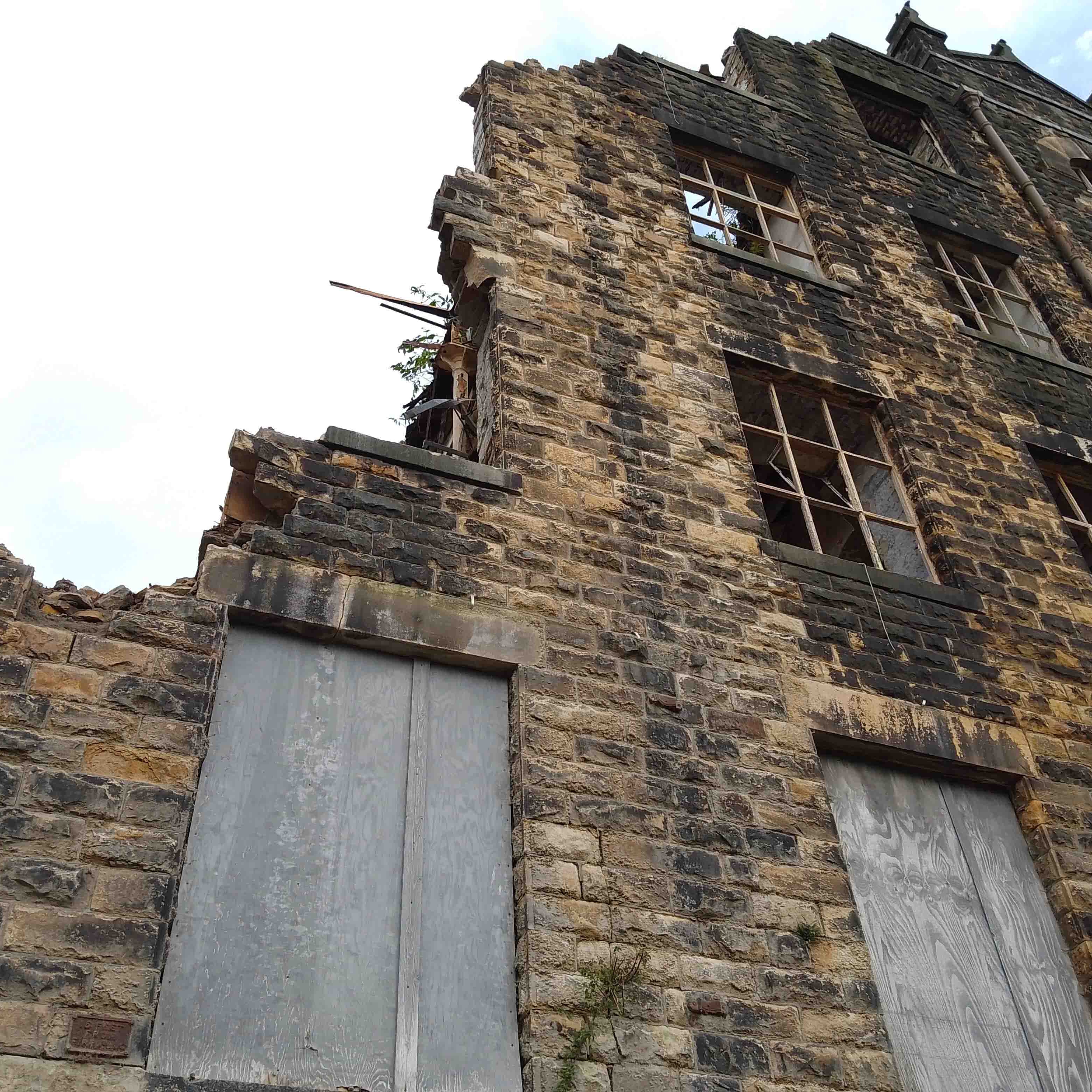 half demolished stone mill in Yorkshire with reclamation team on site