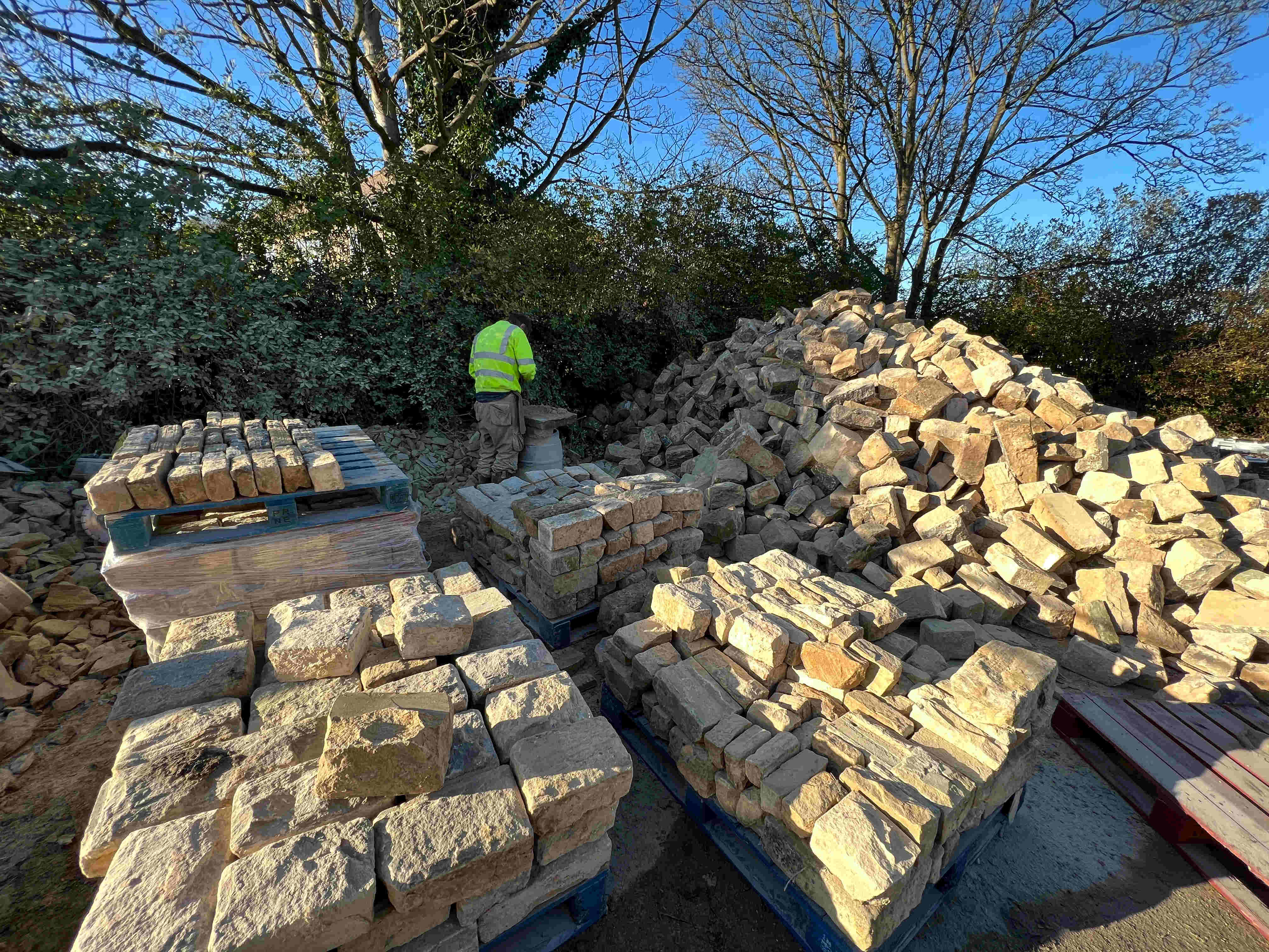 Stone mason dressing reclaimed stone