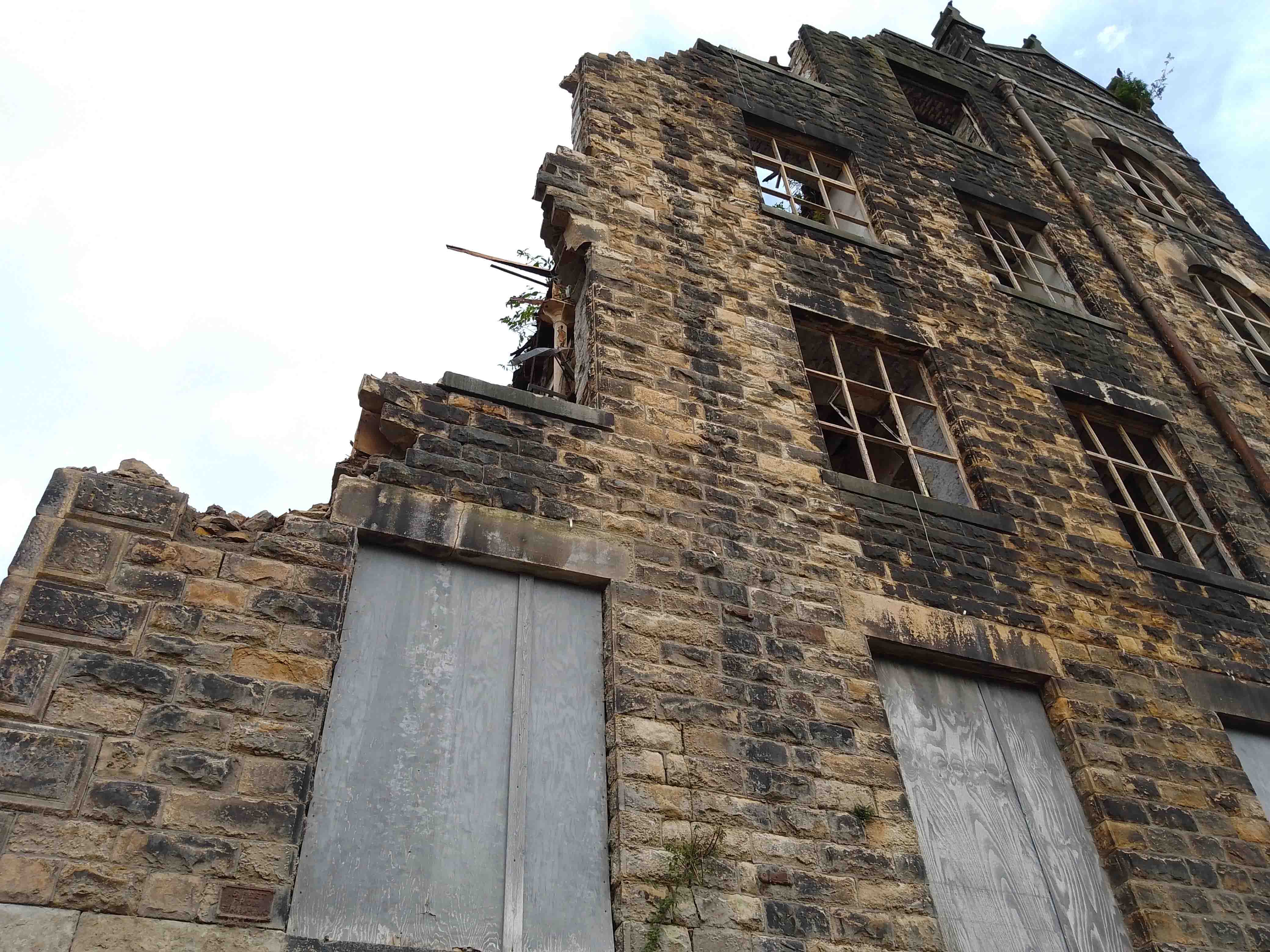 half demolished stone mill in Yorkshire with reclamation team on site